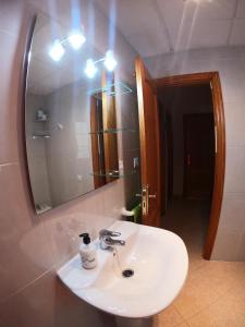 ein weißes Waschbecken in einem Badezimmer mit einem Spiegel in der Unterkunft Apartamento junto el mar, internet de un IG in Gran Tarajal + 36 Fotos