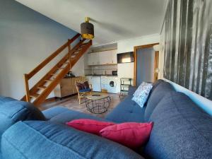sala de estar con sofá azul y almohadas rojas en Apartamentos Nevandi, en Pido