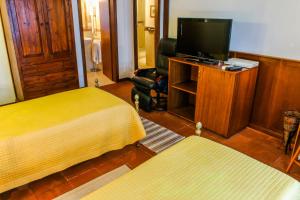 レッジョ・ディ・カラブリアにあるAl Cortilettoのベッドルーム(ベッド1台、テレビ、椅子付)