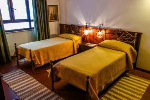 レッジョ・ディ・カラブリアにあるAl Cortilettoのベッド2台と窓が備わるホテルルームです。