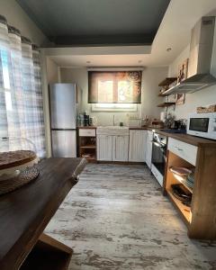 een keuken met een houten tafel en een koelkast bij Galaxidi Sea View Apartment , Galaxidi in Galaxidhion