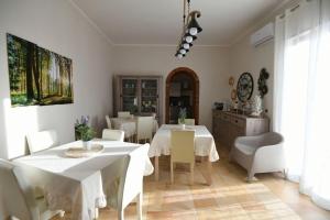 a dining room with white tables and white chairs at Imperial Park in Raffadali