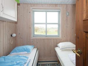 エーベルトフトにあるHoliday Home Skonnertvejのベッド2台と窓が備わる小さな客室です。