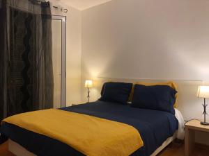 a bedroom with a bed with blue and yellow sheets at Apartment Alameda with Sea View in Machico