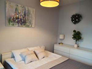 a bedroom with a white bed with a painting on the wall at Platinum Towers by City Apartments in Warsaw