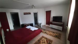 a bedroom with a red bed and a flat screen tv at Pension Waldburg in Râşnov