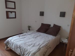 ein Schlafzimmer mit einem Bett mit einer weißen Bettdecke in der Unterkunft DANS LA MAISON D'A COTE in Azerables