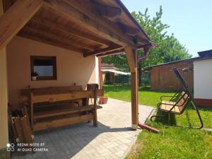 a patio with awning and a bench in a yard at Dům Hana in Nejdek