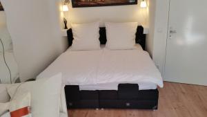1 cama con sábanas blancas y almohadas en una habitación en Green Oasis, en Berlín