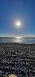 einen Strand mit Felsen und der Sonne am Himmel in der Unterkunft Complejo Soliera in Playa Unión