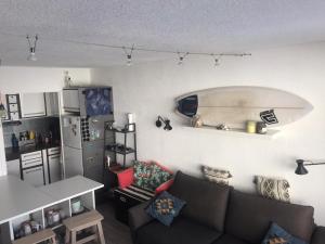a living room with a couch and a surfboard on the wall at Mon studio pour 4 à Val Claret ! in Tignes