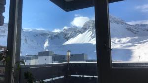 een raam met uitzicht op een met sneeuw bedekte berg bij Mon studio pour 4 à Val Claret ! in Tignes