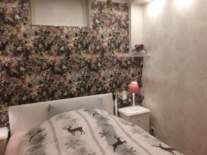 a bedroom with a bed with a floral wallpaper at Ferienhaus-stadtkyll Beim Förster in Stadtkyll