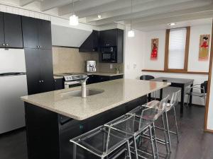 a kitchen with a island with a counter and stools at Panorama Ocean & Golf Fairway view in Bodega Bay