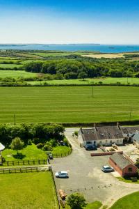 una vista aérea de una granja con coches aparcados en un aparcamiento en Little Hilton Farm, en Haverfordwest