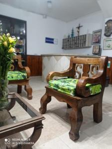 een kamer met 2 stoelen en een vaas met bloemen bij Hotel Plaza Calarcá in Calarcá