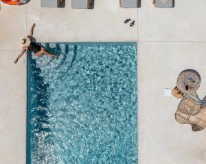 una persona está nadando en una piscina en Sea & Olives Suites Hotel and Villas, en Plaka