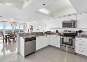 a kitchen with white cabinets and stainless steel appliances at Bahia Mar Solare Tower 6th floor Bayview Condo 2bd 2ba with Pools and Hot tubs in South Padre Island