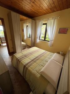 a bedroom with a bed in a room with windows at Goddess Yard in Tropea