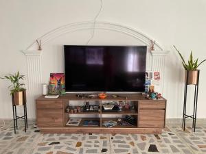 a large entertainment center with a flat screen tv at MonDieu Hostel in Barranquilla