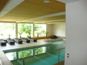 a room with a pool and chairs and a large window at Hotel des Alpes in Flims