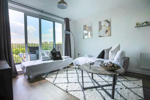 a living room with a couch and a table at Penthouse Apartment - City Centre - Free Parking, Balcony, Fast Wifi and Smart TV with Netflix by Yoko Property in Milton Keynes