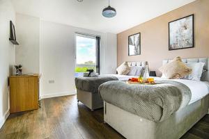a bedroom with two beds and a window at Penthouse Apartment - City Centre - Free Parking, Balcony, Fast Wifi and Smart TV with Netflix by Yoko Property in Milton Keynes