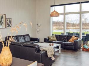 ein Wohnzimmer mit 2 Ledersofas und einem Tisch in der Unterkunft 14 person holiday home in Glesborg in Glesborg