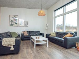 ein Wohnzimmer mit 2 Sofas und einem Tisch in der Unterkunft 14 person holiday home in Glesborg in Glesborg