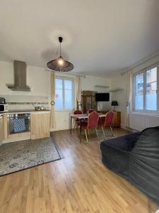a living room with a couch and a table with chairs at Le Cosy Strasbourg calme et confortable avec parking gratuit, 10 mn du Parlement Européen et du Wacken de 1 à 24 voyageurs in Schiltigheim