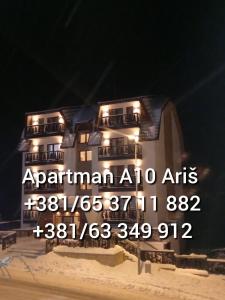 um sinal em frente a um edifício à noite em Apartmani Sorak Kopaonik, hotel Aris, Apartman A10 em Kopaonik