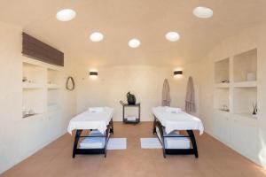 dos mesas en una habitación con mesas blancas y estanterías en Terme di Vulci Glamping & Spa, en Canino