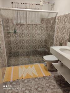 a bathroom with a shower and a toilet and a sink at Casa da Lili-ESPAÇO INDEPENDENTE E PRIVATIVO in Brotas