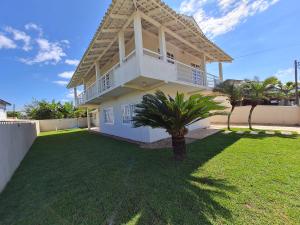 a house with a lawn in front of it at Ampla casa com 5 quartos e vista para o mar in Navegantes