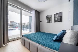 a bedroom with a bed and a large window at Lake Chill Apartment in Ostróda