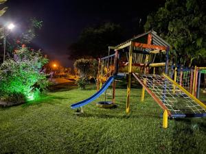 a playground with a slide in the grass at night at Finca La Colmena De Don Juaco in Montenegro