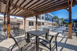 uma mesa e cadeiras debaixo de uma pérgola ao lado de uma piscina em Best Western Plus Flagler Beach Area Inn & Suites em Palm Coast