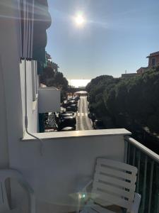 モネーリアにあるCasa Bianca 4 - confortevole in centro a Monegliaのベンチ付きのバルコニーから通りの景色を望めます。
