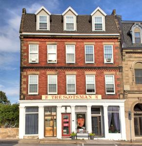 um edifício de tijolos vermelhos com uma loja em frente em The Scotsman Inn em Pictou