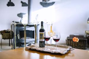 a bottle of wine and two glasses on a table at Os 5 Sentidos in Mourão