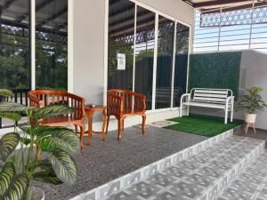 a porch with two benches and a table and chairs at Private pool Cassa Dinies, Wifi , Bbq,10 pax in Rantau Panjang