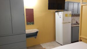 a kitchen with a white refrigerator and a sink at Wallace Holiday Apartments in Scarborough