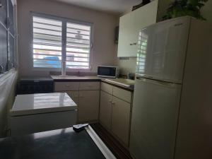 a small kitchen with a refrigerator and a window at Private Beachfront House in Cabo Rojo