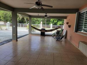 eine abgeschirmte Veranda mit einer Hängematte an einem Haus in der Unterkunft Private Beachfront House in Cabo Rojo