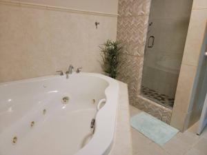 a white bath tub in a bathroom with a shower at Private Beachfront House in Cabo Rojo