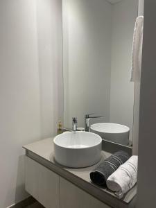 a white bathroom with a sink and a mirror at Apartasuite de lujo Distrito 90 in Barranquilla