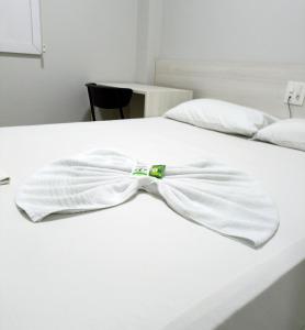 a white bed with a bow tie on it at MFG Hotel in Cianorte
