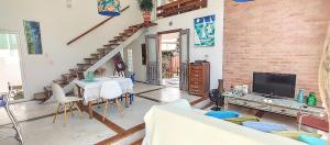 a living room with a table and a tv at Maison de L'ocean Praia 250 m in Florianópolis