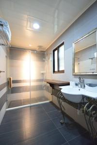 a bathroom with a glass shower and a sink at Ji Li Ya Lan Homestay in Chenggong