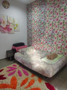1 dormitorio con 1 cama con papel pintado de flores en Maxim Apartment en Pantai Cenang
